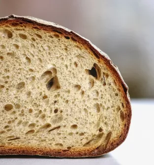 Tradycyjny chleb wiejski wypiekany w piecu opalanym drzewem - pszenny z ziarnami pestek dyni, słonecznika
